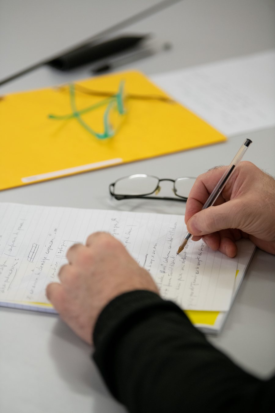 Un participant prend des notes pendant un atelier d'éloquence.